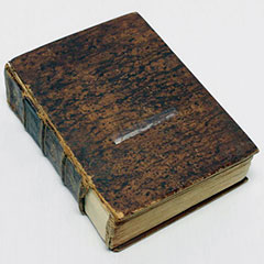 Colour photograph of the leather and fabric cover of a dictionary.