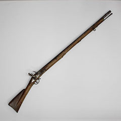 Photographie couleur d'un mousquet en bois avec des pièces de fer.