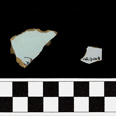 Colour photograph of two broken earthenware shards. On One of them, the Borden Code is visible. The other one displays dark blue patterns.