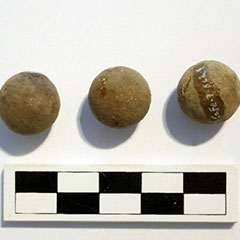 Colour photograph of three lead bullets. On one of them, the Borden Code is visible.