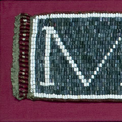 Colour photograph of a two meter long wampum. It is made of eleven rows of shell beads.