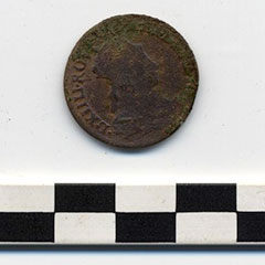 Photographie couleur d'une pièce de monnaie en cuivre avec une inscription et une image du roi de l'époque.