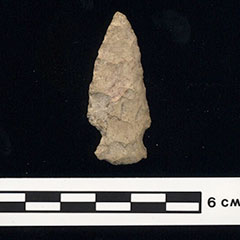 Color photograph of an arrowhead made of stone.