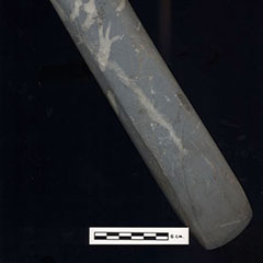Color photograph of an elongated stone with a concave end.