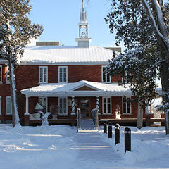 Colour photograph of the exterior facade, in red bricks, of the Musée, in winter. The ground is covered in snow.