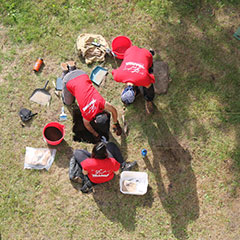 Colour photograph of an aerial view of the team digging an archeological test pit.