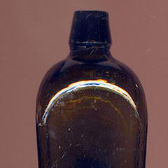 Colour photograph of a glass bottle.
