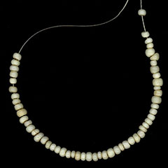 Colour photograph of a white glass beads necklace.