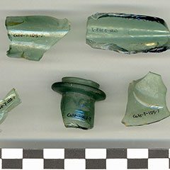 Colour photograph of five glass bottle shards. The Borden code written in black ink on all of them.