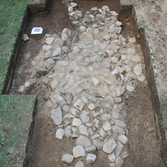 Colour photograph of several stones forming the remains of the foundation of the chapel.